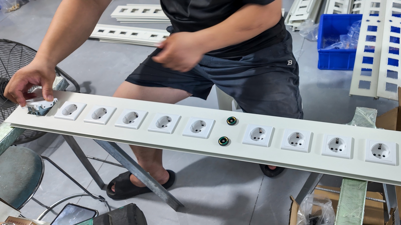 Fitting the European-standard power socket modules into the panel.