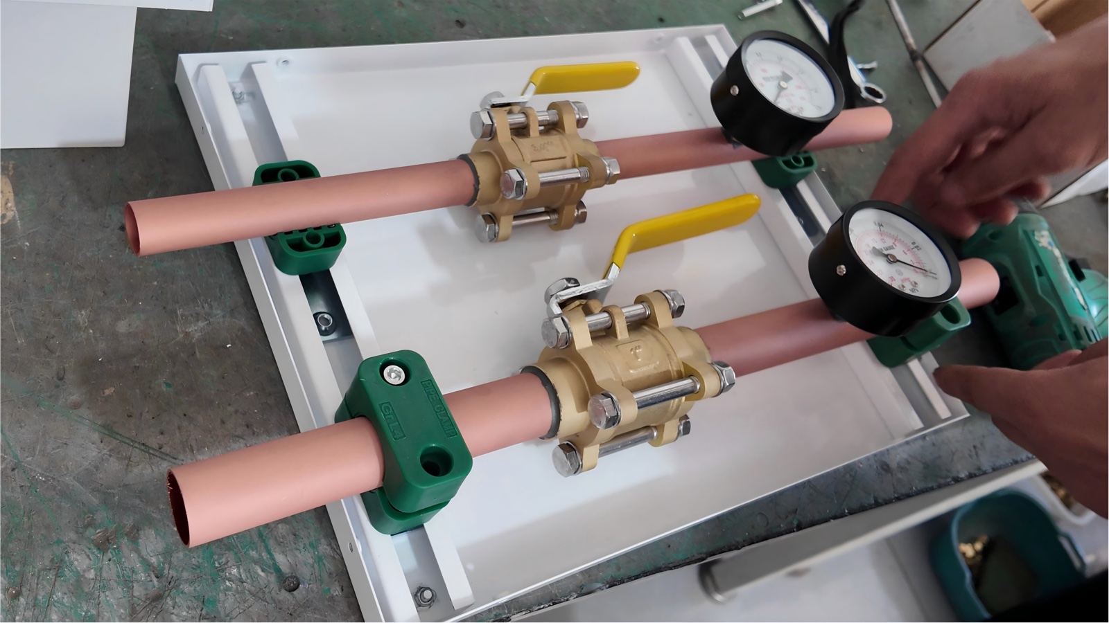 Copper pipe runs and brass ball valves fitted inside the box body.