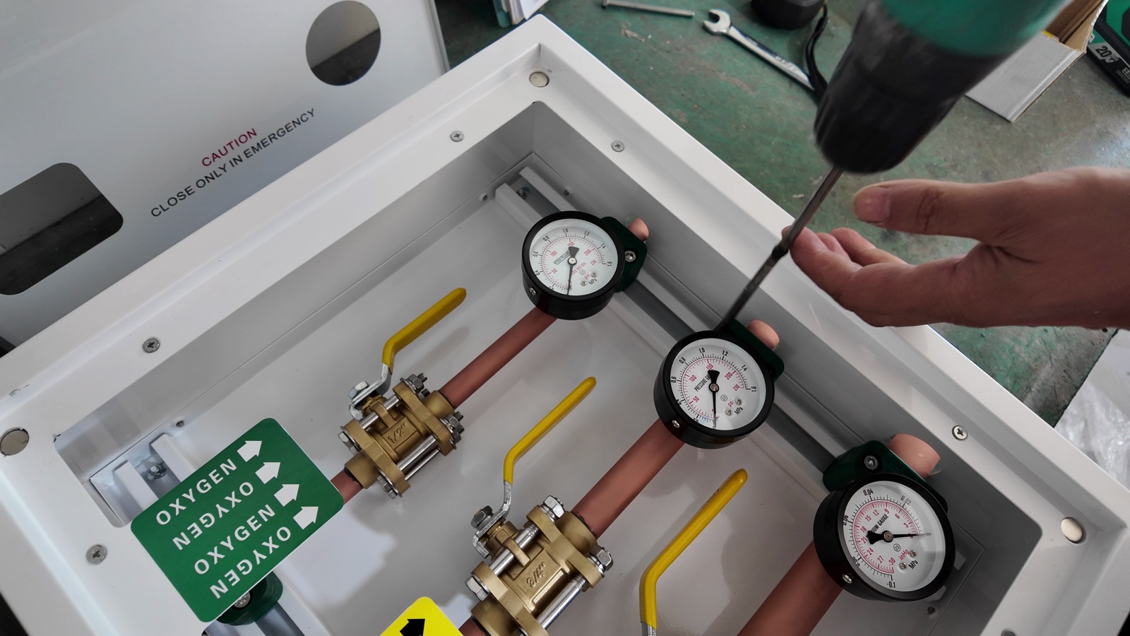 Mounting a pressure gauge inside the box with a power driver.