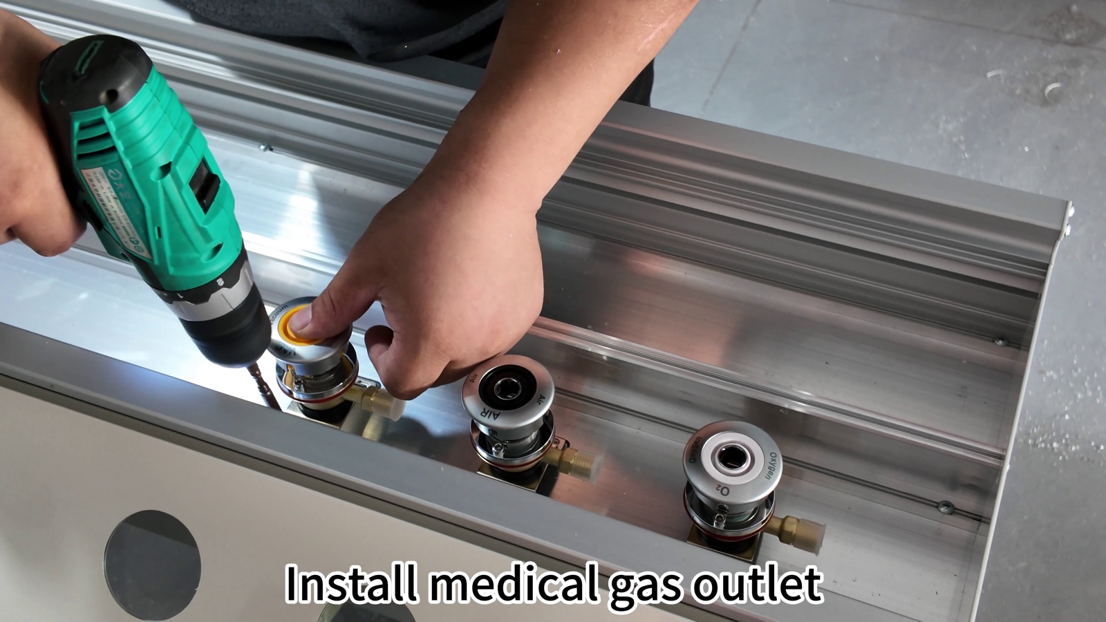 Fitting a medical gas outlet into the outlet band and securing it from the rear.