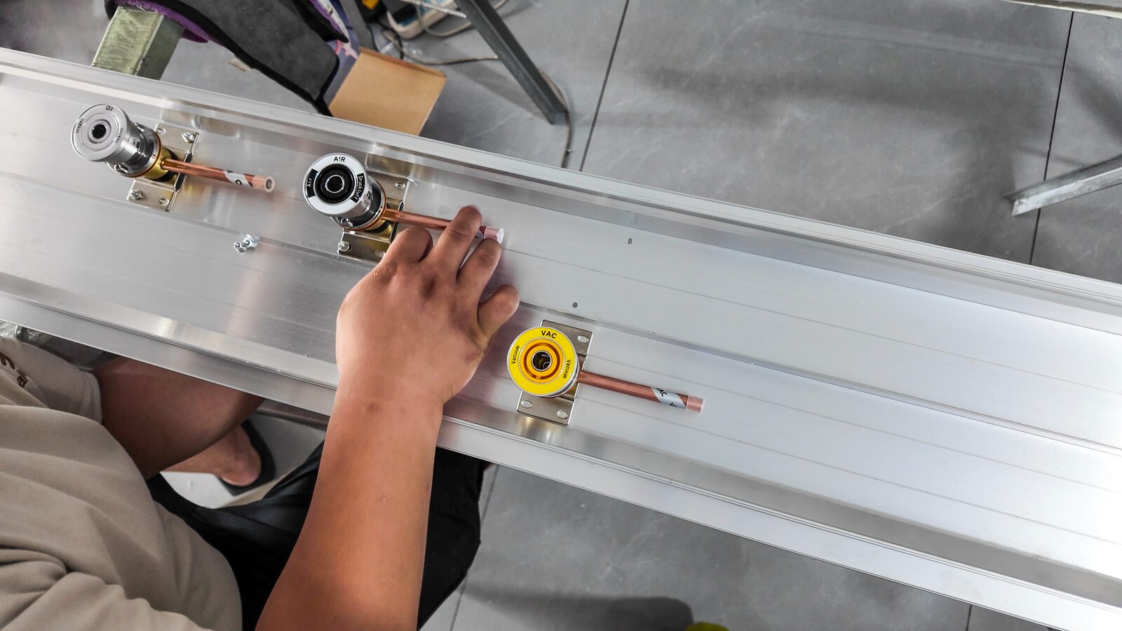 Worker fitting outlet components to a bed head unit panel