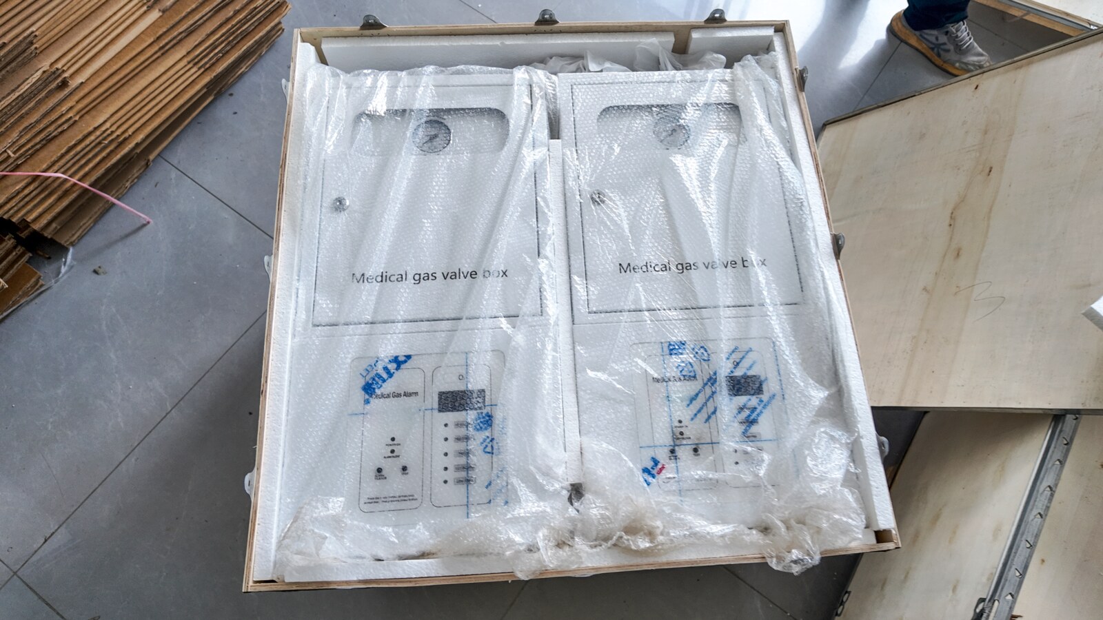 Wrapped medical gas valve boxes positioned in a wooden crate.
