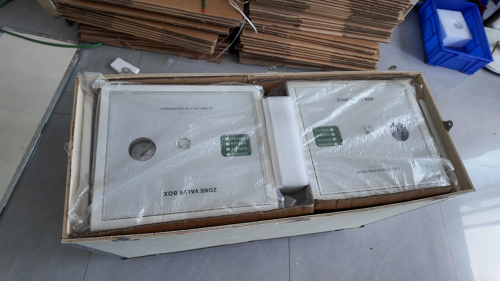 Two wrapped zone valve boxes inside a wooden crate